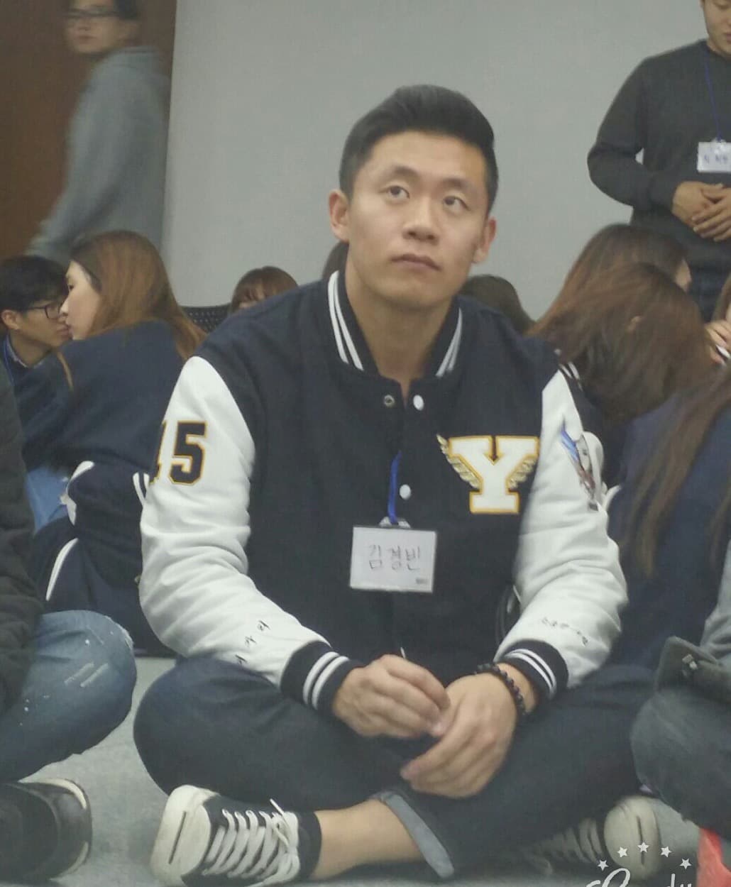 KB Kim at a university event, wearing a Yonsei varsity jacket